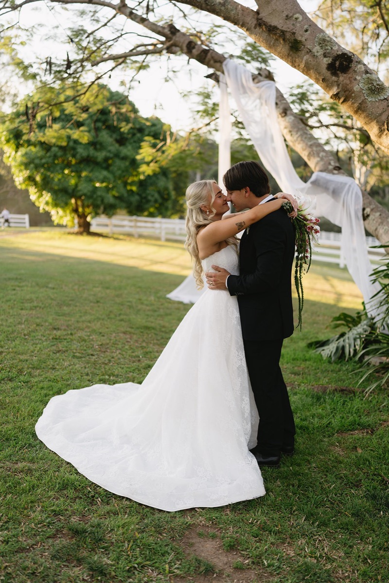 Bride and groom embracing under a draped tree, photographed by SoulFlare Weddings